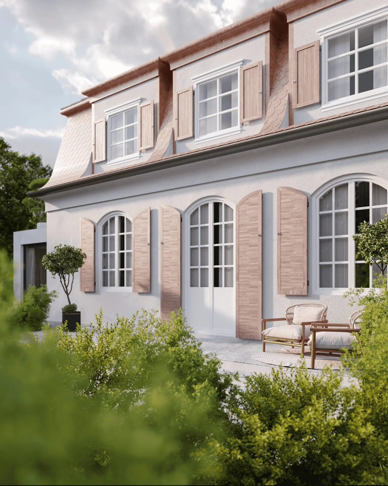 Ein zweistöckiges Haus mit hölzernen Fensterläden an Bogenfenstern, umgeben von Grün. Auf der Terrasse steht eine Bank. Im Hintergrund ein bewölkter Himmel.