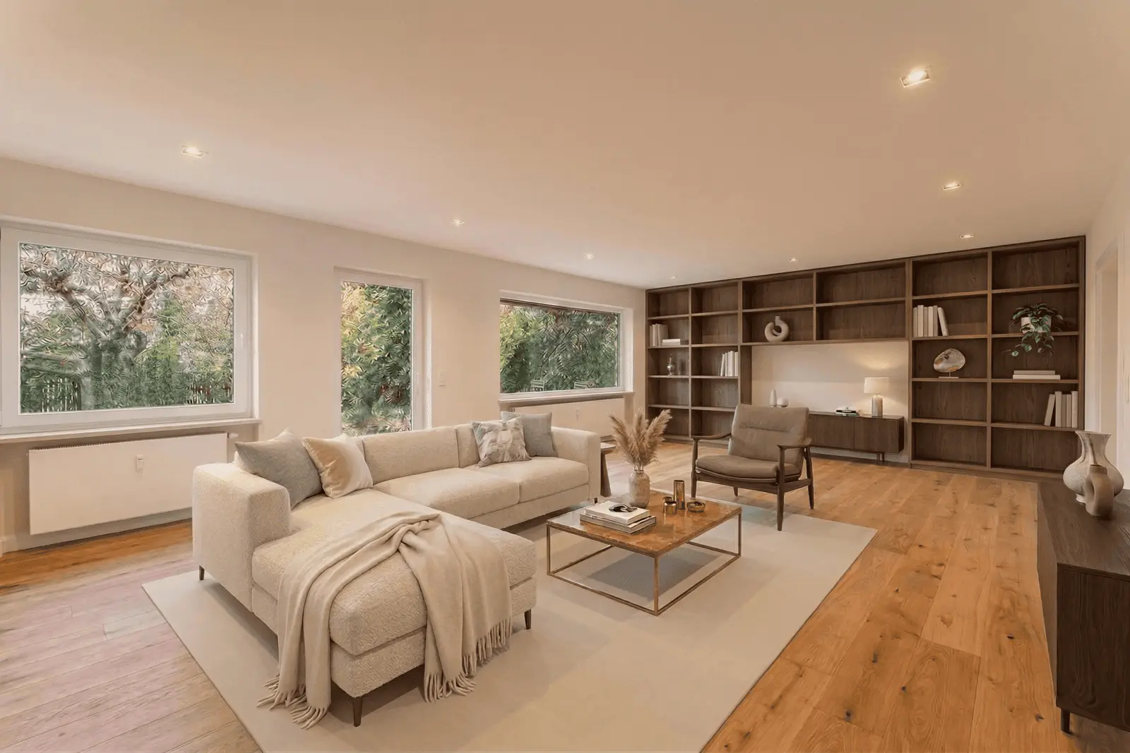 Ein geräumiges Wohnzimmer mit einem beigen Sektionssofa, einem Sessel, einem Couchtisch aus Holz, eingebauten Regalen, großen Fenstern und Hartholzböden.